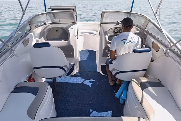 Interior view of an exclusive Paraty boat tour, showcasing modern seating and a captain steering across tranquil waters.