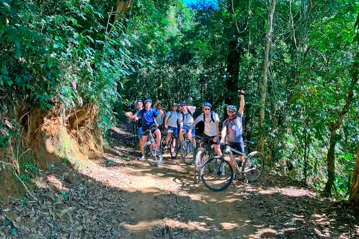 Group of cyclists enjoying a guided bike tour through the lush forest trails of Paraty, capturing the adventure spirit.