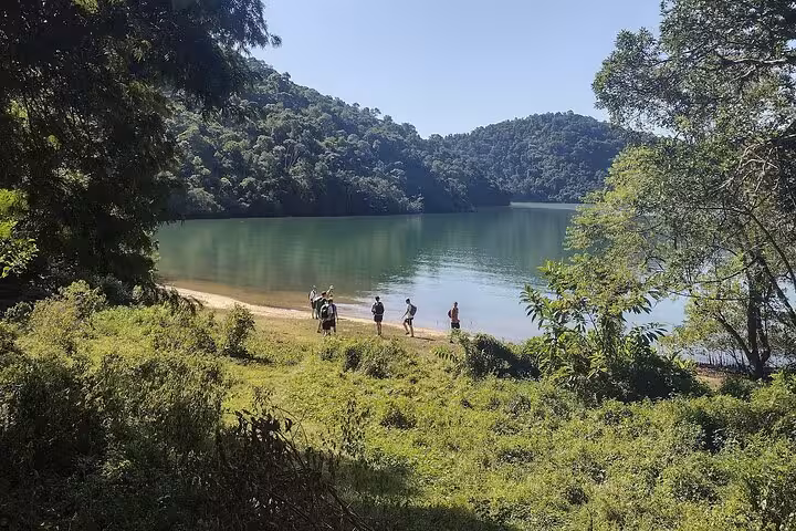 Tour group enjoying the serene view of a tranquil lake and lush forest on a Paraty bike tour.