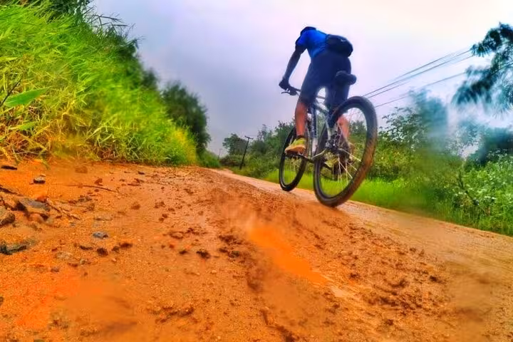 Cyclist navigating a muddy trail in Paraty, showcasing the adventurous terrain of the 2-hour guided bike tour.