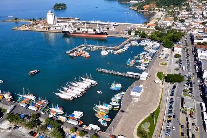 Aerial view of Paraty harbor showcasing colorful boats and the vibrant coastline, key point for Ilha Grande transfers.