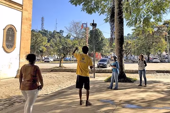 Tour guide leading a group through Paraty's historical center, showcasing colonial architecture and lush surroundings.