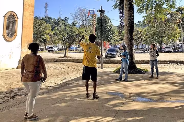 A tour guide leads a small group through Paraty's cobblestone streets on a historical tour with Paraty Tours.