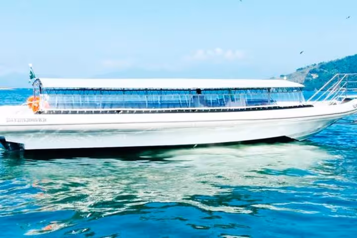 Side view of a sleek transfer boat on clear waters, facilitating travel from Paraty to Ilha Grande.