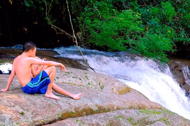 Relax by a serene waterfall in Paraty's natural landscape, perfect for a peaceful moment during your jeep tour adventure.