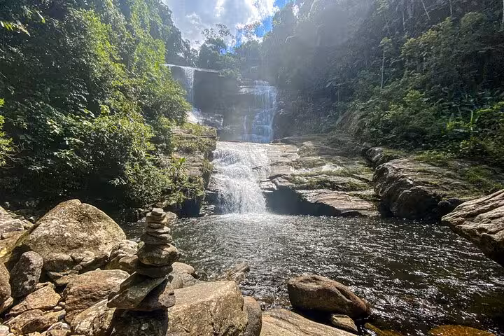 Scenic Melancia Waterfall surrounded by dense forest and rocks, perfect for trekking and hiking tours in Paraty.