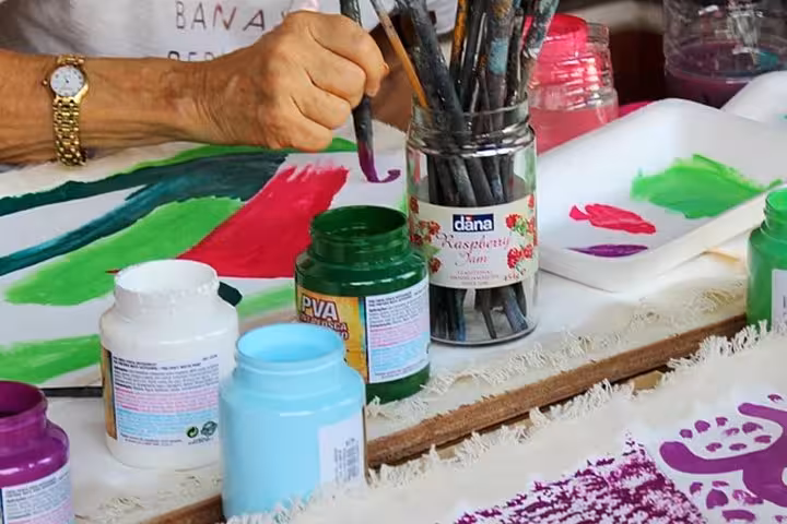 Colorful paints and brushes on a table during a Paraty art class, showcasing hands-on creativity and artistic exploration.