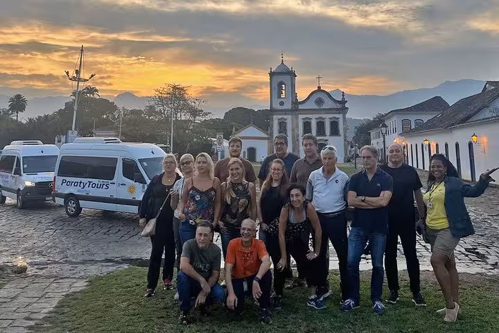 Group of travelers enjoying a scenic tour in Paraty with sunset views, ready to transfer to Rio de Janeiro.