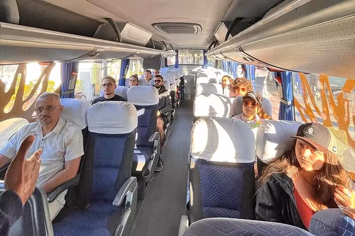 Passengers seated comfortably inside a modern tour bus for shared transfers from Paraty to Rio de Janeiro.