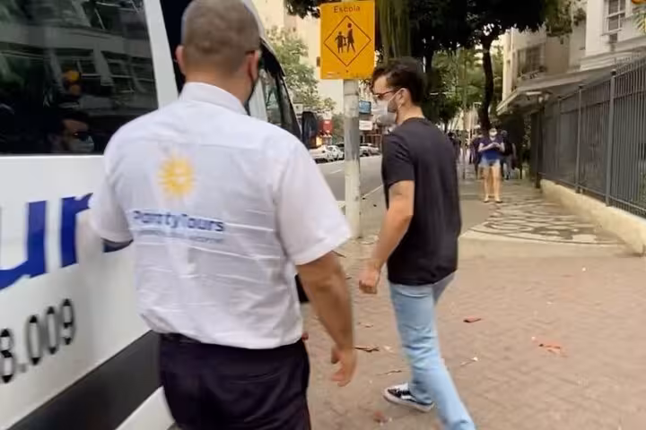 Passenger boarding a shuttle with a guide in Paraty, illustrating the start of a shared trip to São Paulo.