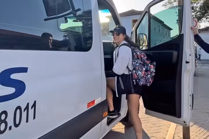 Traveler boarding a shuttle in Paraty for a shared transfer to São Paulo, showcasing convenient transport service.