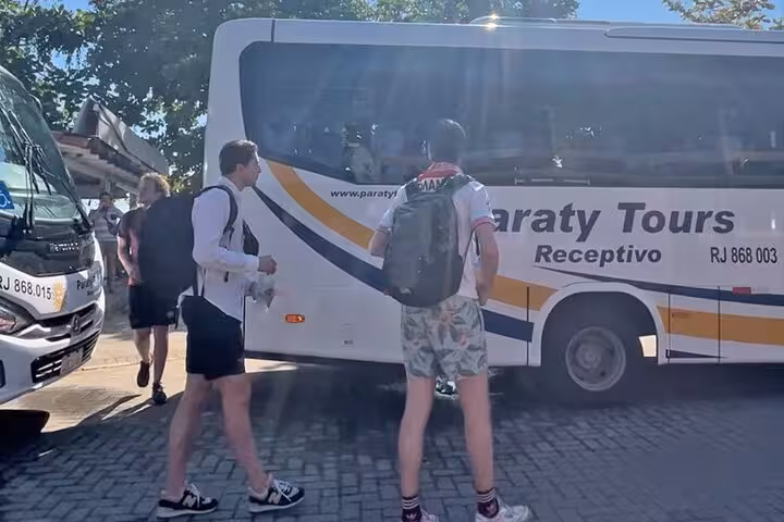 Passengers preparing to board a Paraty Tours shuttle bus for a shared transfer to São Paulo, highlighting group travel.