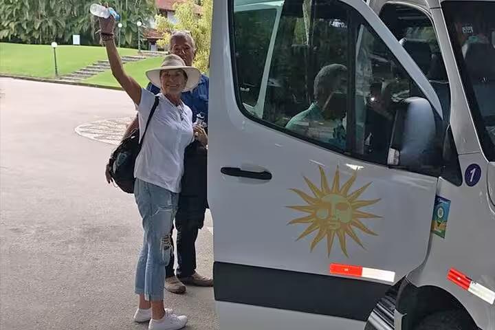 Tourist boarding a Paraty Tours van for a shared transfer to Ilha Grande, highlighting convenient travel services.