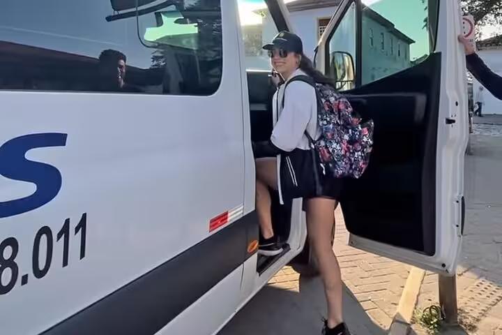 Traveler entering a shared transfer van from Paraty to Rio de Janeiro hotels, showcasing easy and accessible transportation.