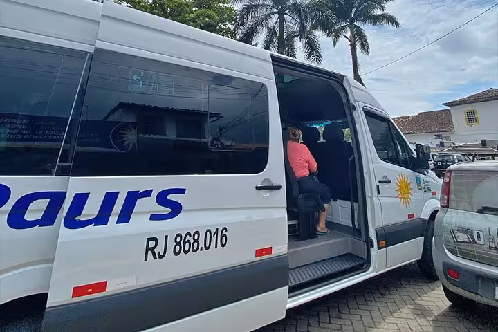 Paraty Tours shuttle van parked with door open, ready for passengers traveling from Rio to Angra dos Reis.