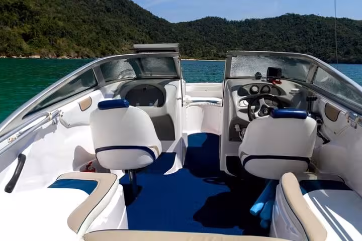 Interior view of a modern speedboat in Paraty, featuring comfortable seating and scenic ocean backdrop.