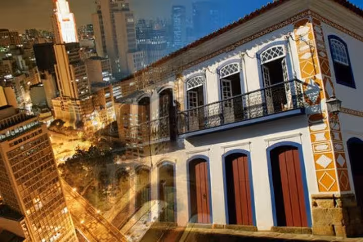 Blended image of Paraty's colonial architecture and São Paulo skyline, highlighting travel journey.