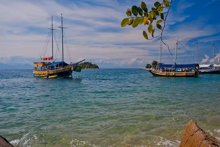 Two traditional boats anchored in picturesque blue waters during a Paraty Tours boat tour, perfect for scenic exploration.