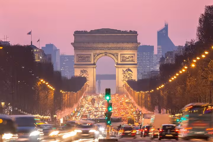 Arc de Triomphe at dusk with Champs-Élysées lights, private Paris tour itinerary featuring macaron tasting