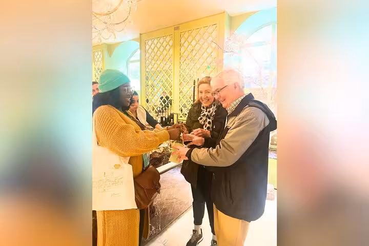 Guests sample Paris macarons in a chic patisserie during a private Champs-Élysées and Arc de Triomphe tour