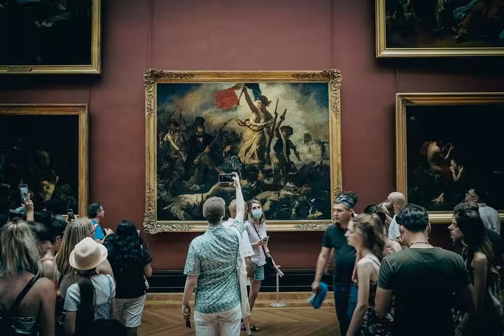Visitors photographing Delacroix Liberty Leading the People at the Louvre, included with Full Day Paris City Pass