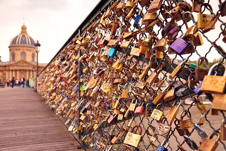 Love locks on a Paris bridge with historical architecture in the background, perfect for a family-friendly city highlights tour.