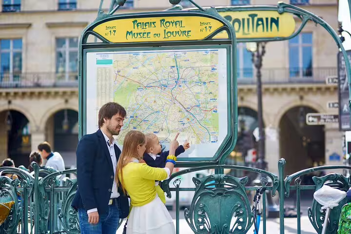 Family explores Paris map at Palais Royal metro, ideal for private family tours and kid-friendly museum visits.