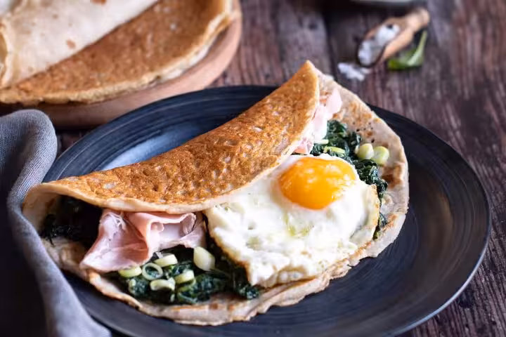 Savor a classic French galette with ham, spinach, and a sunny-side-up egg on the Le Marais food tour in Paris.