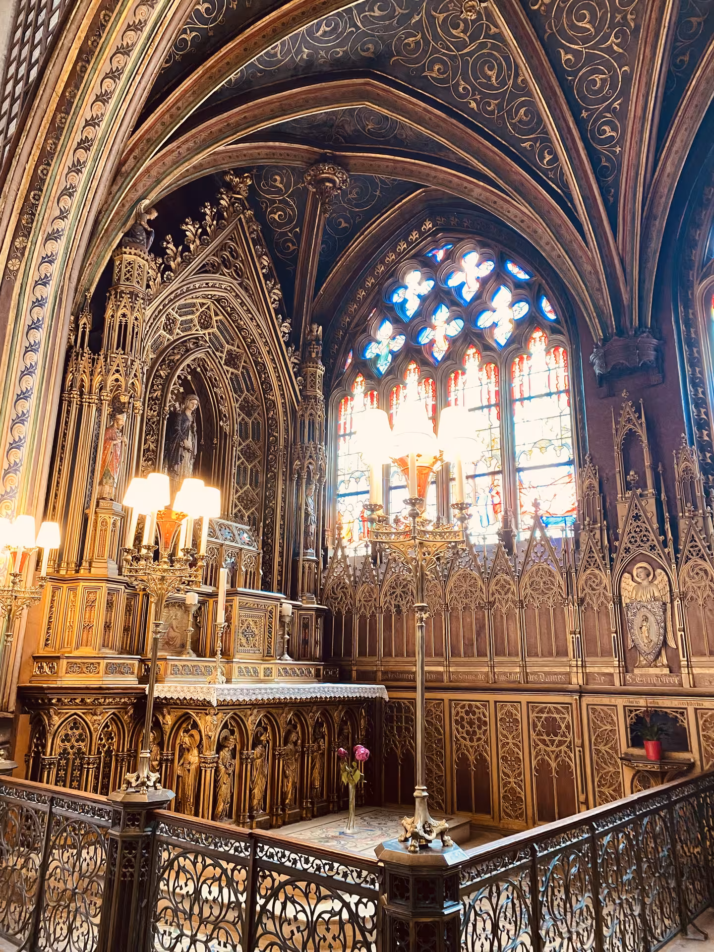 Discover the intricate Gothic details of a chapel's ornate altar and colorful stained glass in Paris' hidden gem.
