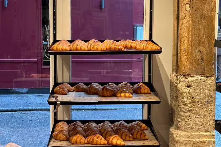 Golden croissants arranged on bakery racks, a highlight of the Paris Gourmet Tour Wine and Fromage Adventure.