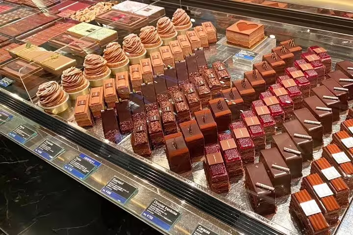 An elegant display of artisan pastries and chocolates in a Parisian patisserie, highlighting gourmet delights on the tour.