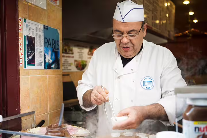 Chef crafting authentic French delicacies in Paris' Le Marais district during a private walking food tour.