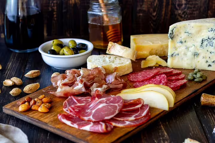 Assorted French charcuterie and cheese platter with olives and bread on a Paris Le Marais food tour, showcasing local flavors.
