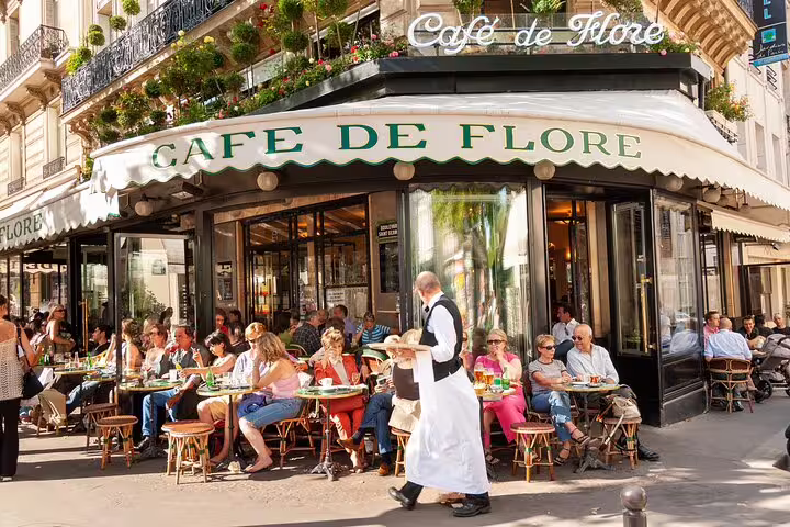 Parisian café scene at the iconic Café de Flore, bustling with visitors enjoying outdoor dining, part of the Paris private tour.