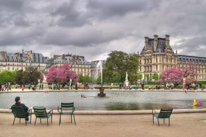 Luxurious Parisian garden scene with vibrant cherry blossoms and historic architecture, perfect for a romantic private tour.
