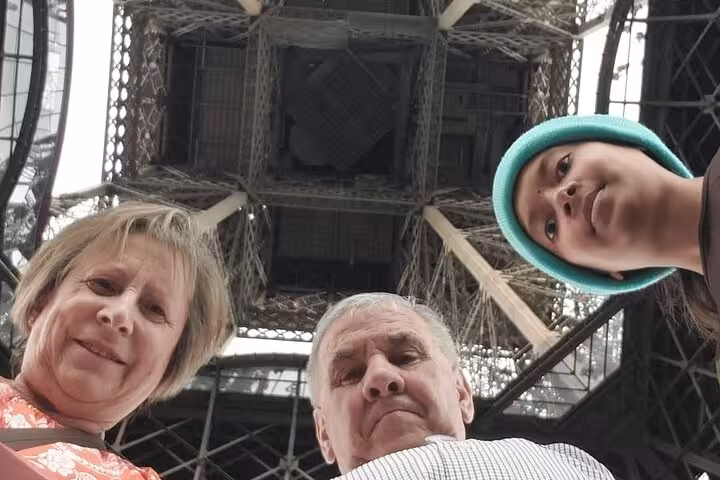 Travelers looking up at the Eiffel Tower during a private Paris half-day guided tour with Seine River cruise