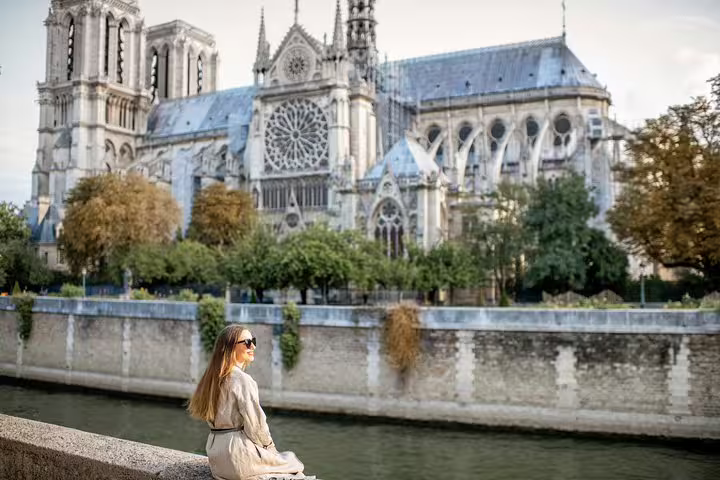 Woman enjoying a scenic view of Notre-Dame Cathedral along the Seine River, highlighting Parisian charm on a private tour.