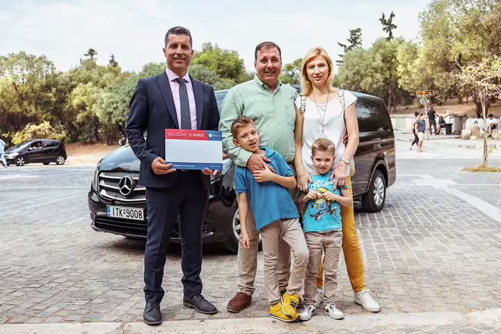 Family welcomed by private chauffeur for Paris to Reims Champagne Region day tour in luxury minivan