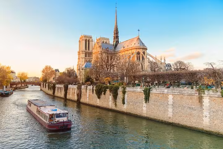 Seine River cruise boat passing Notre-Dame Cathedral, part of Paris half-day tour with private guide and Louvre entry