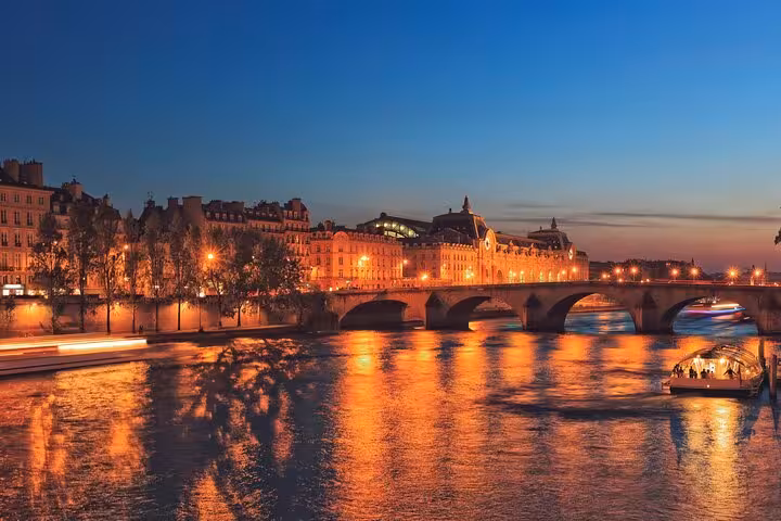 Evening Seine River promenade in Paris with bridge views and cruise boats, part of a private LoveLocks Bridge walk