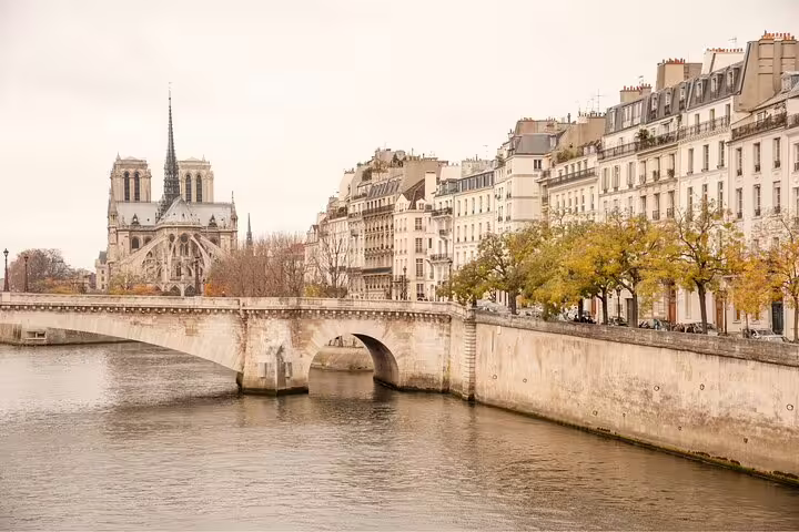 Seine River view with historic Notre-Dame Cathedral and classic Parisian architecture, ideal for crêpes and Eiffel Tower tour.