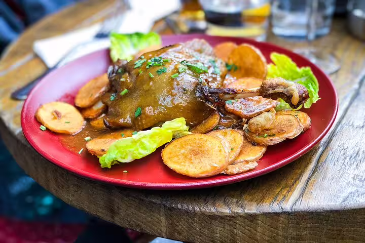 Delicious French cuisine featuring duck confit with crispy potatoes, perfect for a culinary stop on a Paris private full-day tour.