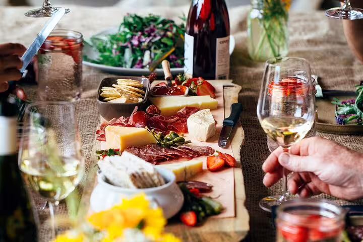 A vibrant spread of cheese, charcuterie, and wine on a rustic table setting during the Paris wine and fromage adventure.