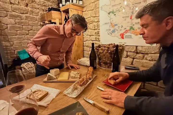 Paris wine and cheese tasting in a cozy cellar, baguette and French cheeses during Napoleon story tour
