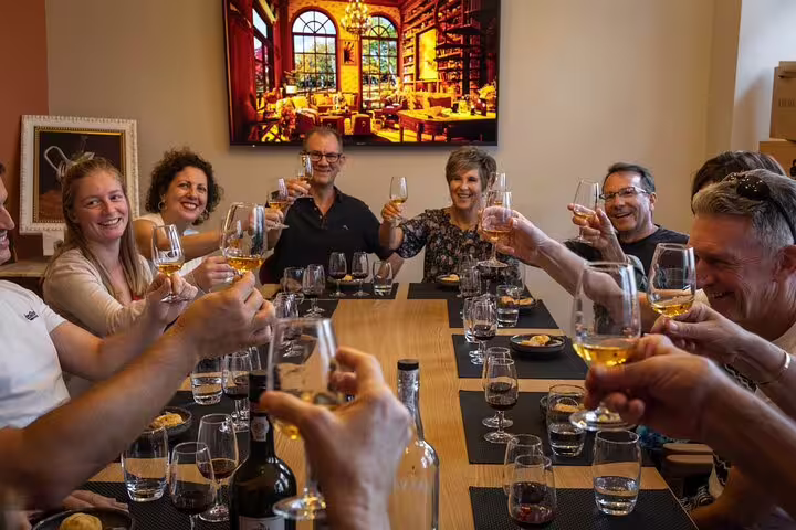 Joyful group enjoying wine tasting in Paris gourmet tour setting.