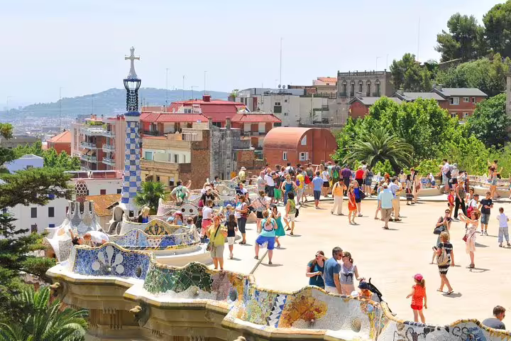 Tourists explore the vibrant mosaic architecture of Park Güell in Barcelona, highlighting a must-see on the Montserrat day tour.