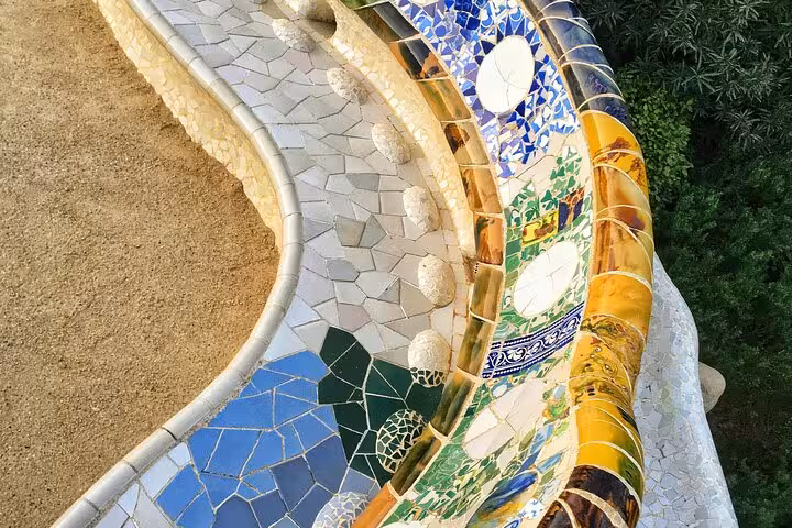 Vibrant mosaic tiles at Park Güell, showcasing Gaudí's iconic architecture on a private Barcelona car tour.