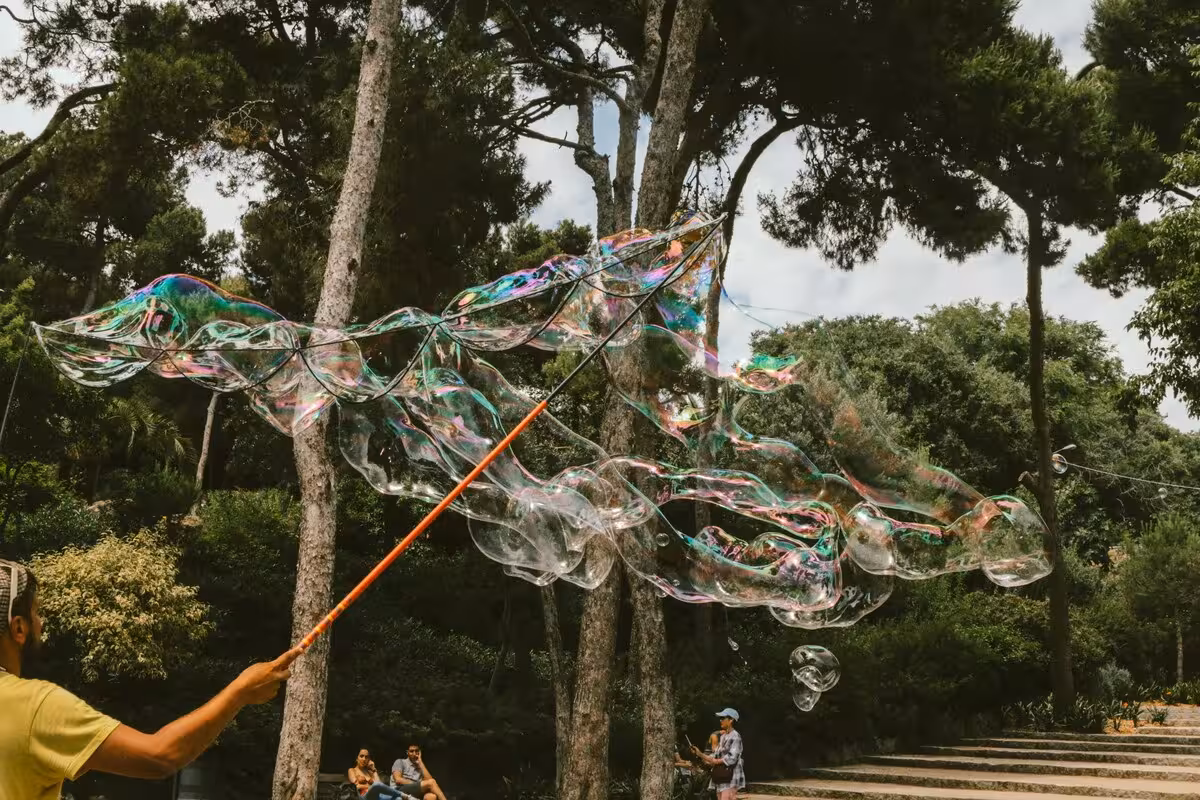 Giant soap bubbles floating in Park Güell gardens on Barcelona UNESCO tour with skip-the-line tickets
