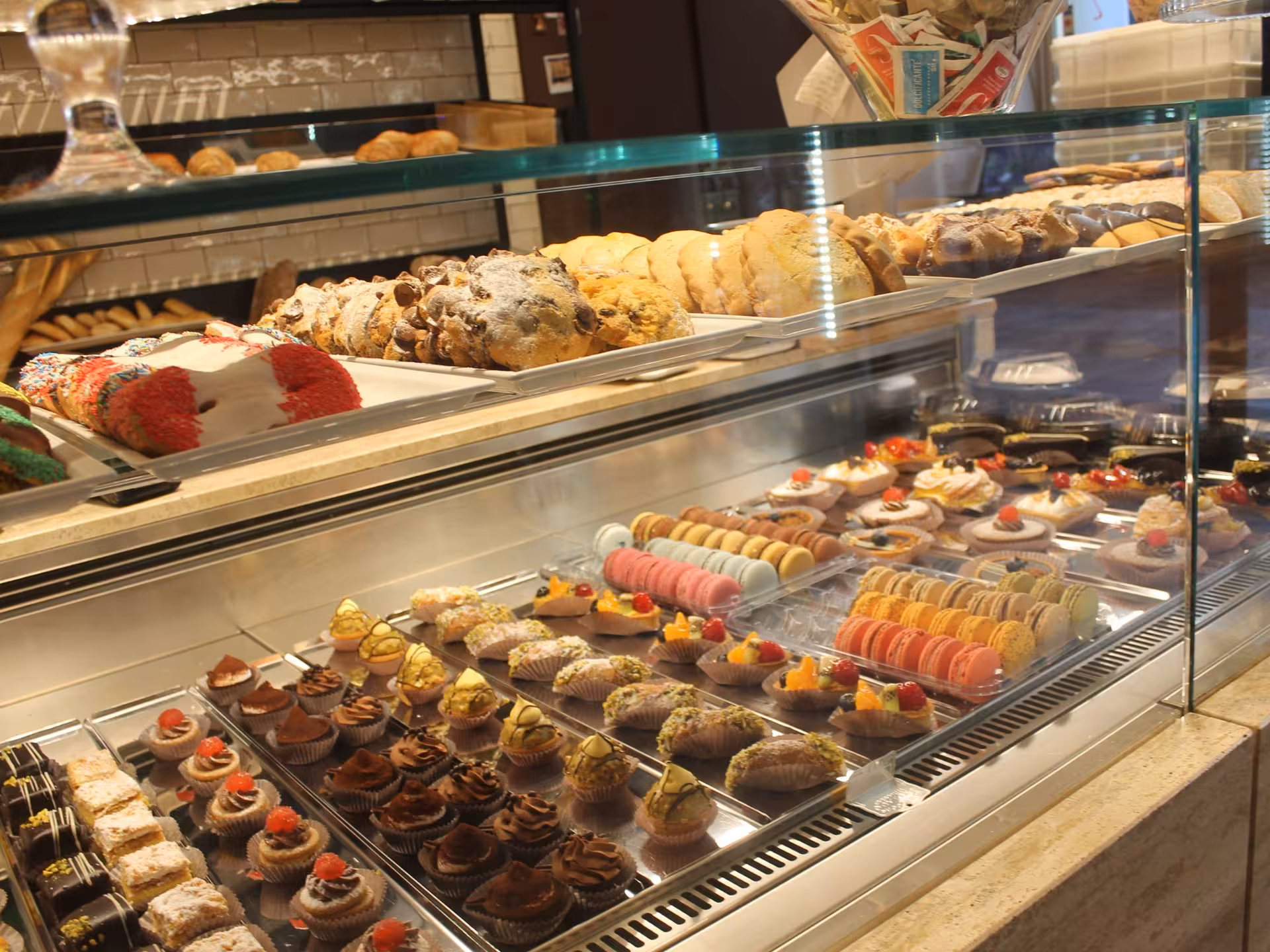 Luxurious pastry display featuring macarons and desserts in Parma's renowned bakery on a food tour.