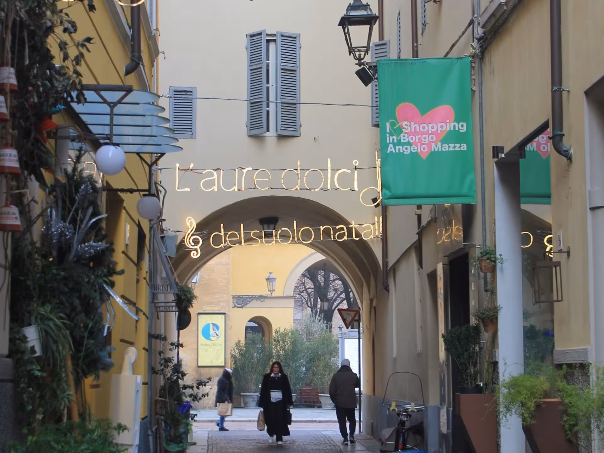 Picturesque shopping street in Parma adorned with festive lights, ideal for exploring during a food tour.
